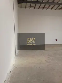 A spacious warehouse is available for rent in the Umm Al Fuwain Industrial Area, featuring a height