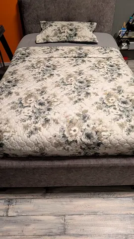 Upholstered bed frame with floral quilt and pillow - good condition