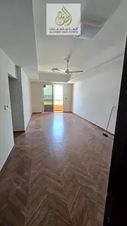 For annual rent in Ajman – Two bedrooms, living room, and balcony