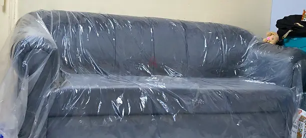 3-seater grey faux leather sofa in good condition (covered)