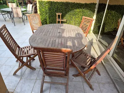 Wooden oval outdoor dining table with 5 chairs.