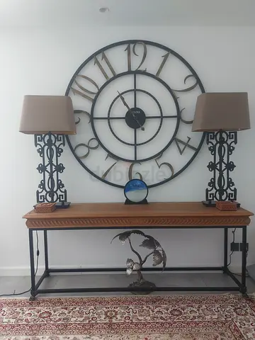 Big wall clock with lamp and table