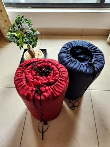 Two lightweight roll-up sleeping bags - navy and red