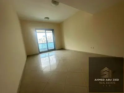 With free air conditioning, the largest two-bedroom apartment with a living room is available for annual rent in Sharjah, featuring built-in wardrobes