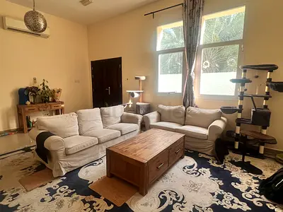 Two beige slipcover sofas with wooden coffee and entry table