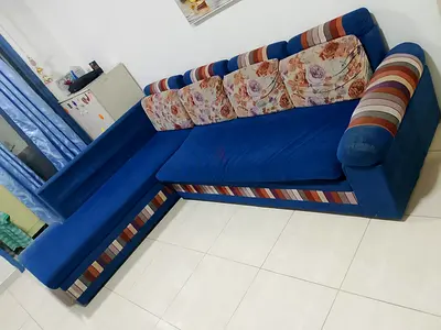 Blue L-shaped Corner Sofa with Floral Cushions — Good Condition