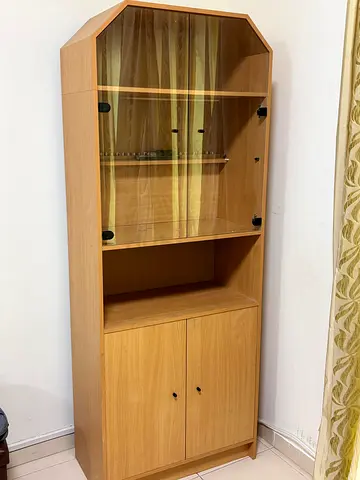 Tall wooden display cabinet with glass doors and storage cupboard