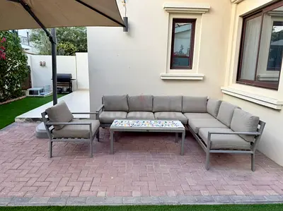 Outdoor L-shaped patio sofa set with adjustable shades, cushions, coffee table and full cover.