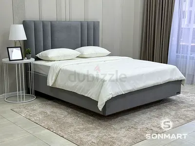 Grey upholstered double bed with padded headboard - good condition