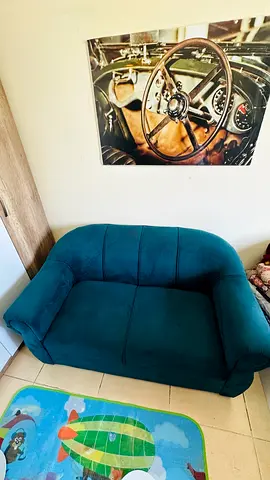 Compact teal two-seater sofa in good condition