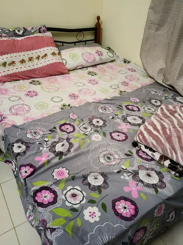 Queen bed with floral bedsheets and pillows