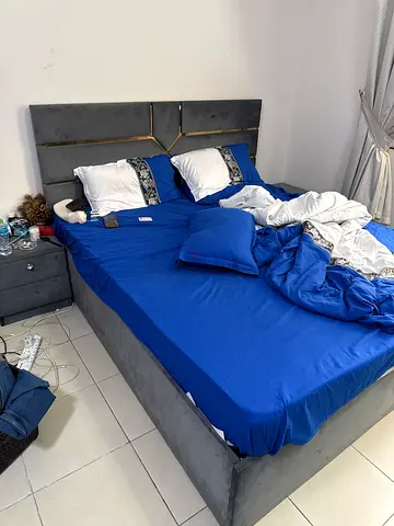 Grey upholstered queen bed frame with padded headboard - good condition