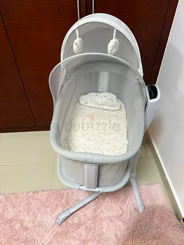 Light grey bedside bassinet with canopy and mobile - gently used