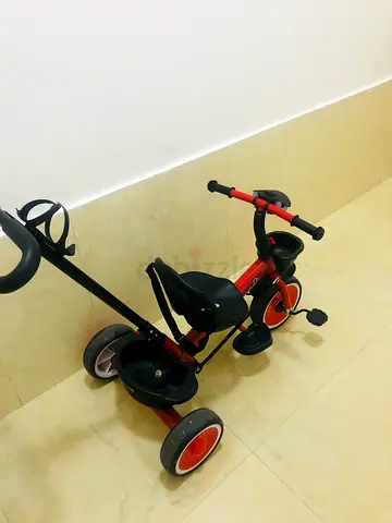 Used red toddler tricycle with push handle — good condition
