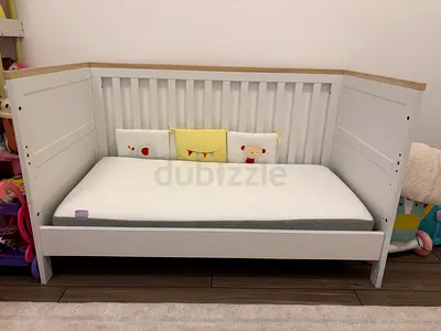 White wooden baby crib with mattress