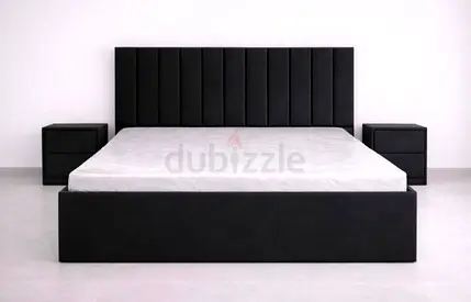 Modern black upholstered king-size bed with matching bedside tables