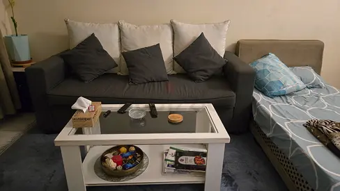 Grey fabric 3-seater sofa with cushions and coffee table