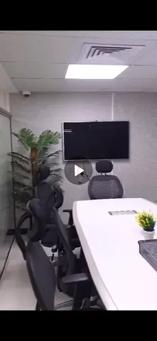 Modern White Conference Table with Ergonomic Office Chairs and Wall-Mounted TV