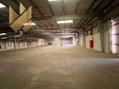 Large warehouse for rent in Al Sajaa with an area of 23,000 sq ft, 37.5 kW electricity, located on a main road.