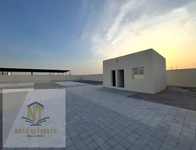 Land for rent in Al Sajaa Fully fenced land with an office and bathroom, suitable for industrial or commercial use, in a prime location. Area: 10,000