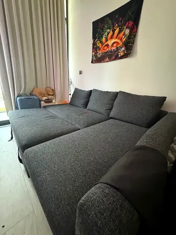 Grey L-shaped Sofa Bed with Cushions — Good Condition