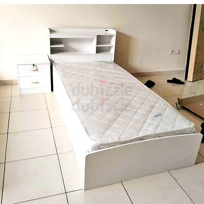 Single white bed with headboard shelves and mattress
