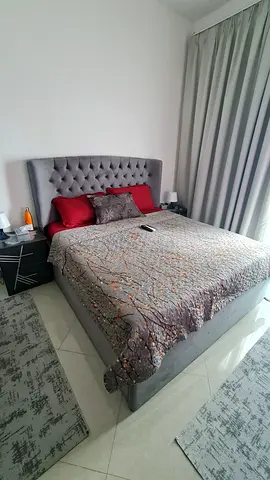 Grey bedroom set consisting of a king-size storage bed, two nightstands, a dresser, and a wardrobe.