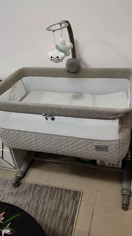 Used bedside bassinet with mobile – neutral beige, good condition