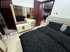A one-bedroom apartment with a living room for cash sale in City Towers, partial view of Sharjah.