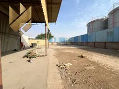 Fenced yard for rent in Al Sajaa, Sharjah, 20,000 sq. ft., fully equipped with rooms, bathrooms, and