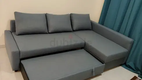 Ikea L-shaped grey fabric sofa with pull-out bed and chaise lounge