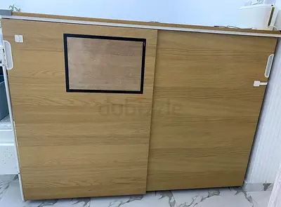 Small sliding-door wooden storage cabinet — light oak finish