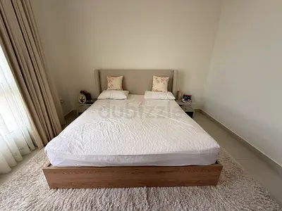 Double wooden platform bed with upholstered headboard and two bedside tables and mattress