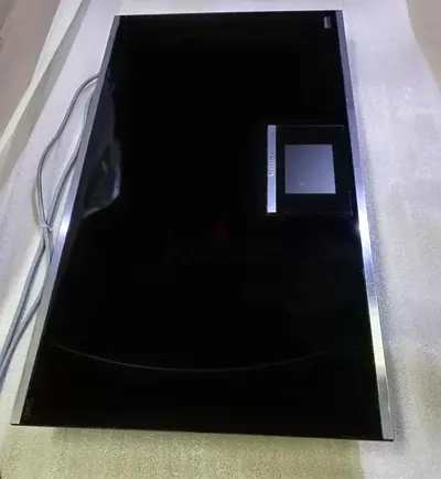 Miele induction cooktop, likely from the Generation 7000 series, featuring a sleek black glass surfa