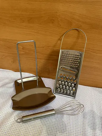 Set of kitchen hand tools: box grater, whisk and spoon rest