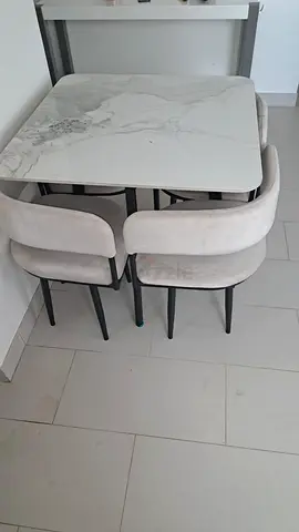 Compact marble-top dining table with 4 upholstered chairs