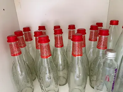 15 glass bottles with red caps
