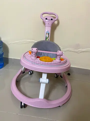 Lightly used pink baby walker with activity tray and handle