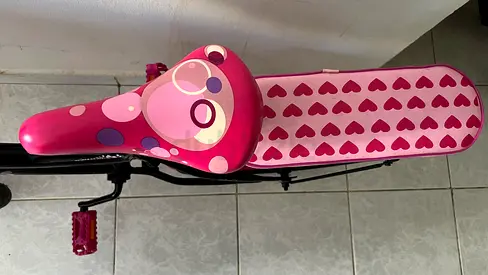 Pink childrens bike with heart-patterned seat — good condition