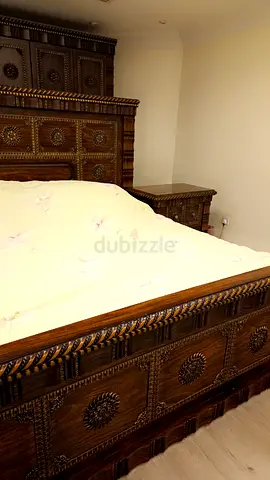 Solid carved wooden king-size bed with matching nightstand