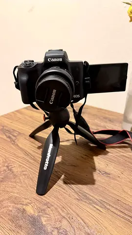 Canon EOS mirrorless camera with flip screen and small Manfrotto tripod