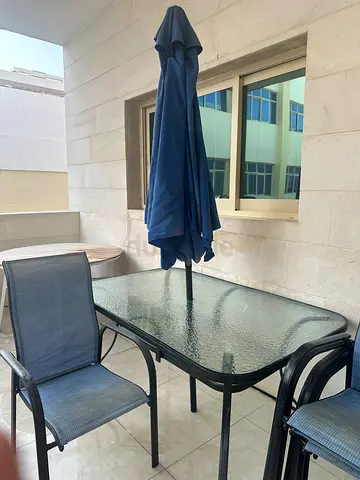 Glass Top Outdoor Dining Table with 6 Mesh Chairs and Blue Umbrella