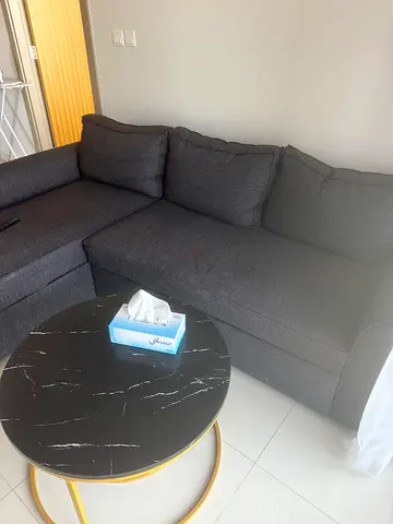 L-shaped grey fabric sofa (corner) with round marble-top coffee table