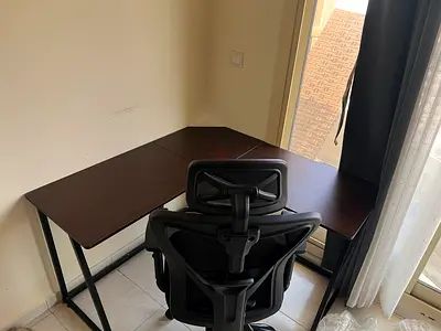 L-shaped dark wood office desk with ergonomic mesh chair - used