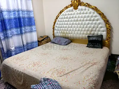 King-size bed with ornate gold-accented tufted headboard