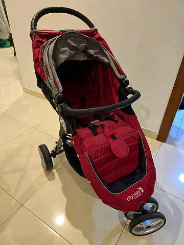 Red three-wheel jogging stroller in good used condition