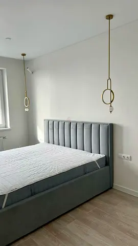 Grey upholstered king-size bed with padded headboard