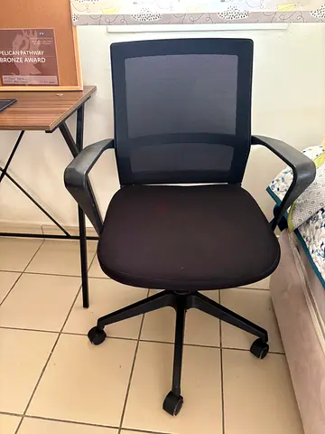 Used black mesh office chair with armrests and caster wheels