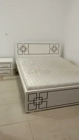 White queen size bed frame with mattress and matching bedside table
