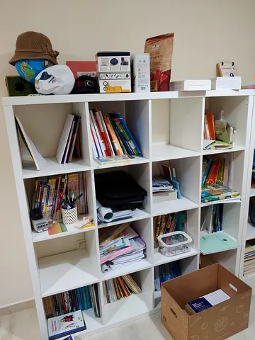 Large White Cube Bookshelf with Mixed Books and Study Materials